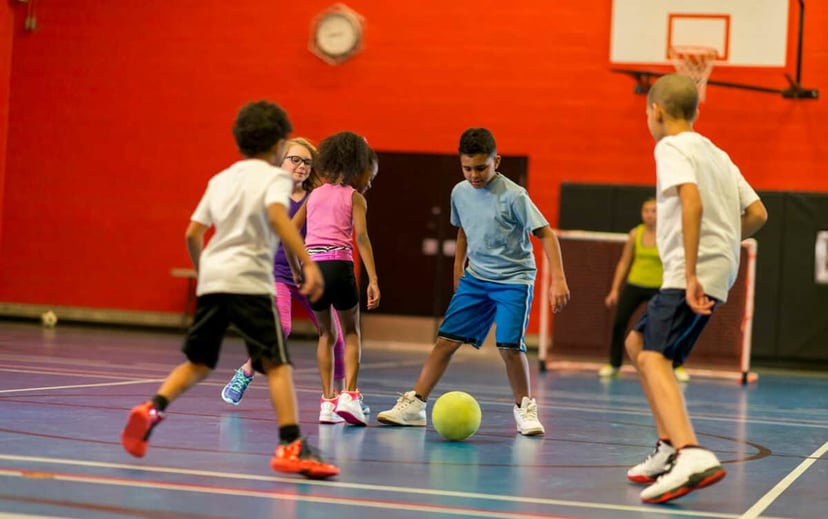 Fotografia d'una classe d'educació física a primària, on els nens practiquen activitats físiques a l'escola.