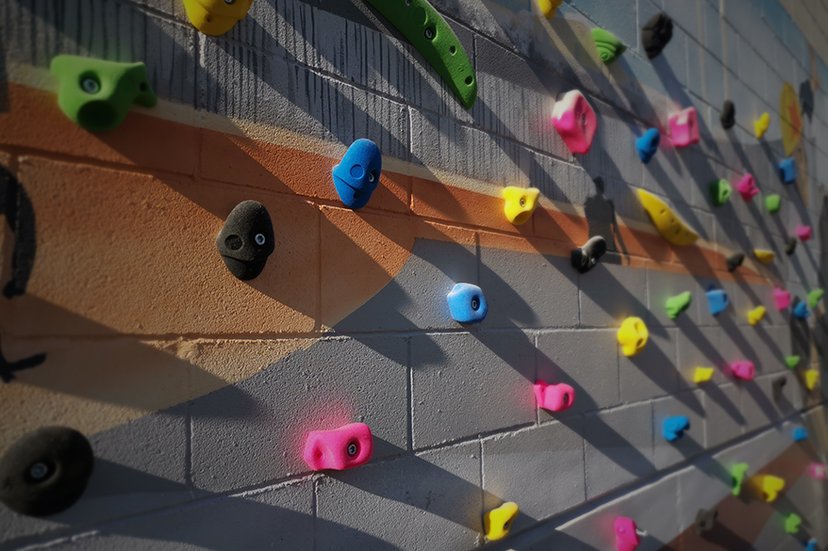 Escalada esportiva (rocòdrom): escalada en un mur artificial amb preses de colors.