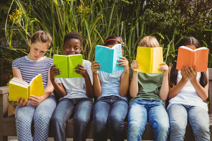 Infants llegint a la biblioteca, descobrint el plaer de la lectura en un espai tranquil i acollidor.